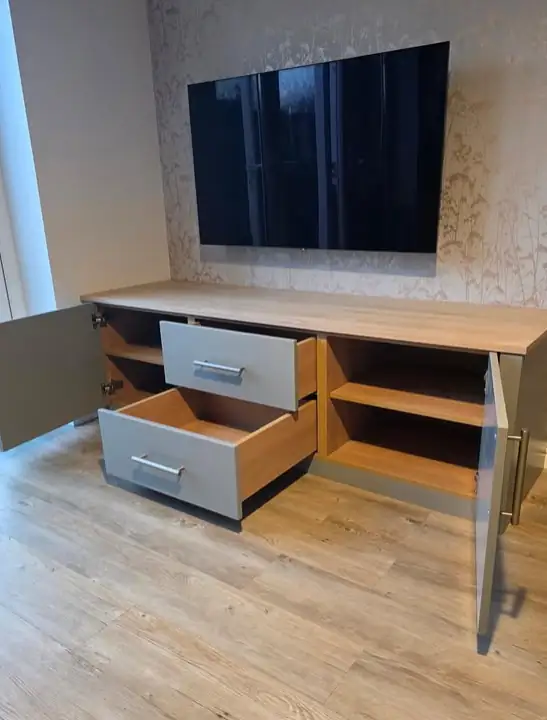 Bespoke TV unit with grey drawers and open oak shelves under a wall mounted TV